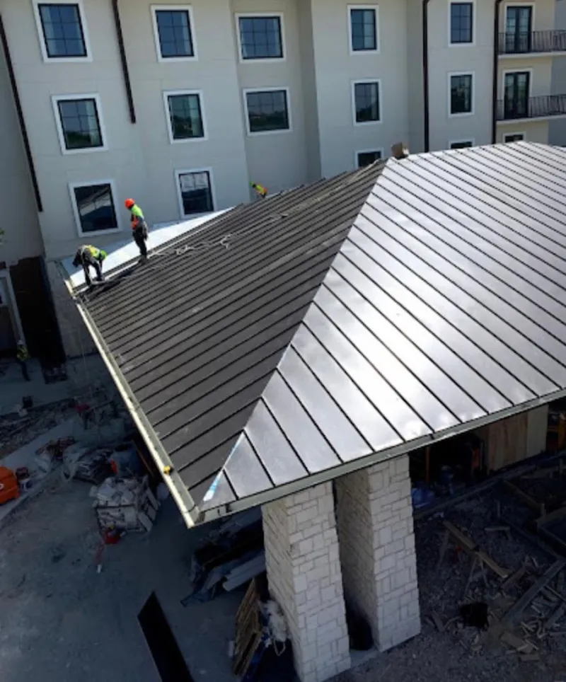 Crew installing standing seam metal roof panels on a commercial project in Gold River